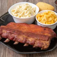 Smoked BBQ ribs served with macaroni salad, mac and cheese and cornbread