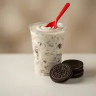 Oreo flurry blended treat with crushed Oreo cookies and a red spoon